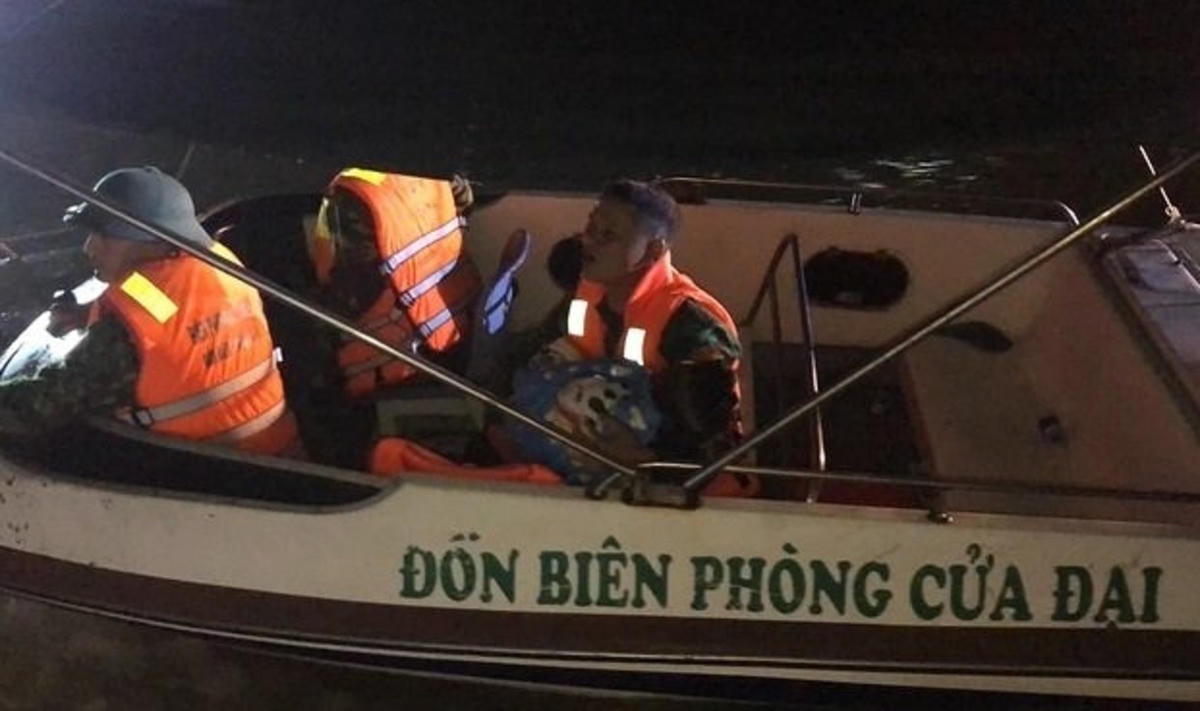 Lực lượng chức năng đưa thi thể cháu L. vào bờ.