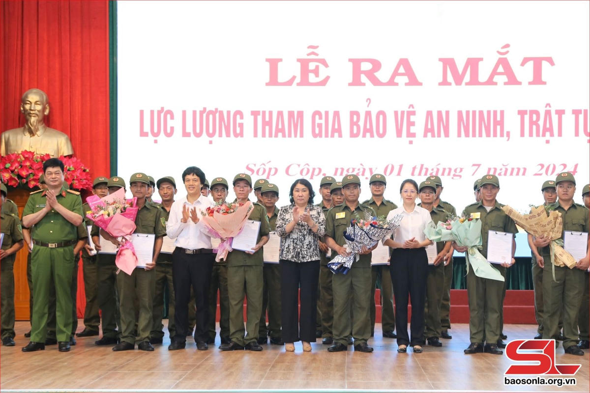 Đồng chí Tráng Thị Xuân và lãnh đạo huyện Sốp Cộp chúc mừng các tổ bảo vệ an ninh trật tự ở xã Sốp Cộp.