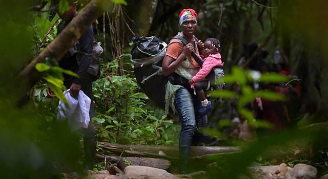 Một người di cư mang theo con nhỏ đang tìm cách vượt qua khu rừng chết chóc Dariem Gap. Nguồn: World Vision.