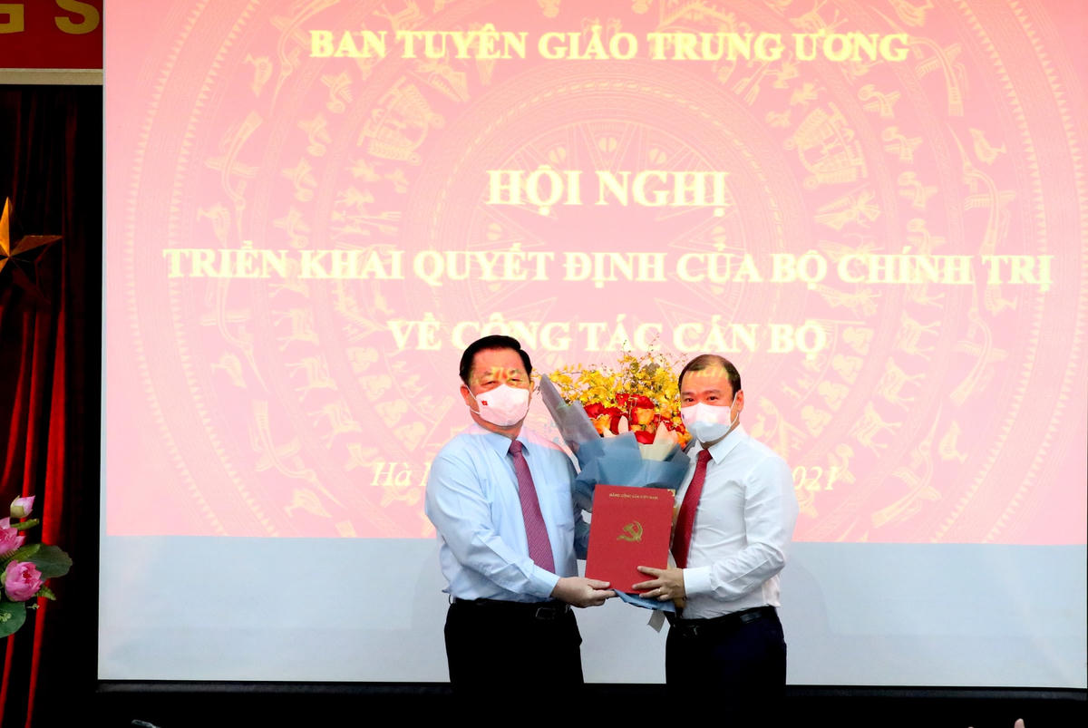 Ông Nguyễn Trọng Nghĩa trao quyết định và tặng hoa chúc mừng ông Lê Hải Bình.