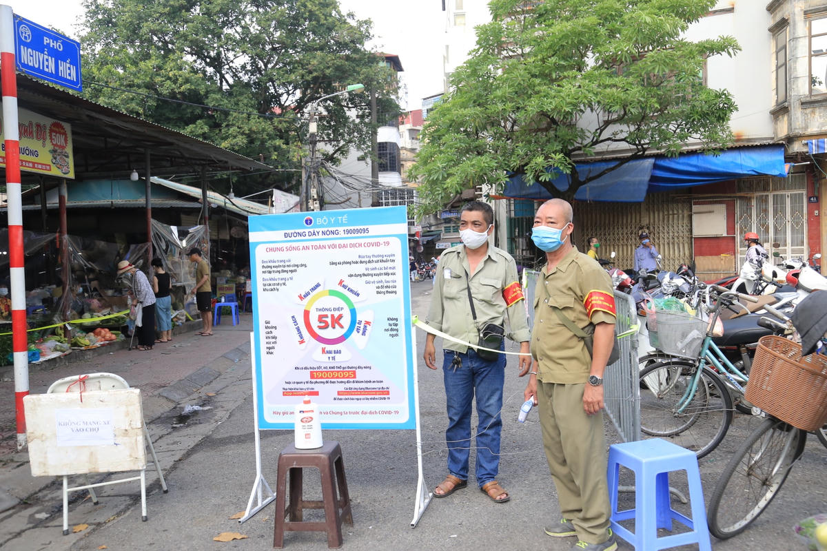 Trước khi vào chợ Bách Khoa mua thực phẩm, người dân phải sát khuẩn tay và thực hiện nghiêm việc đeo khẩu trang, đảm bảo giãn cách.