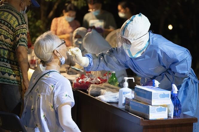 Nhân viên y tế lấy mẫu xét nghiệm Covid -19 cho người dân tại Vũ Hán, tỉnh Hồ Bắc, Trung Quốc, ngày 7/8/2021. Ảnh: THX/ TTXVN