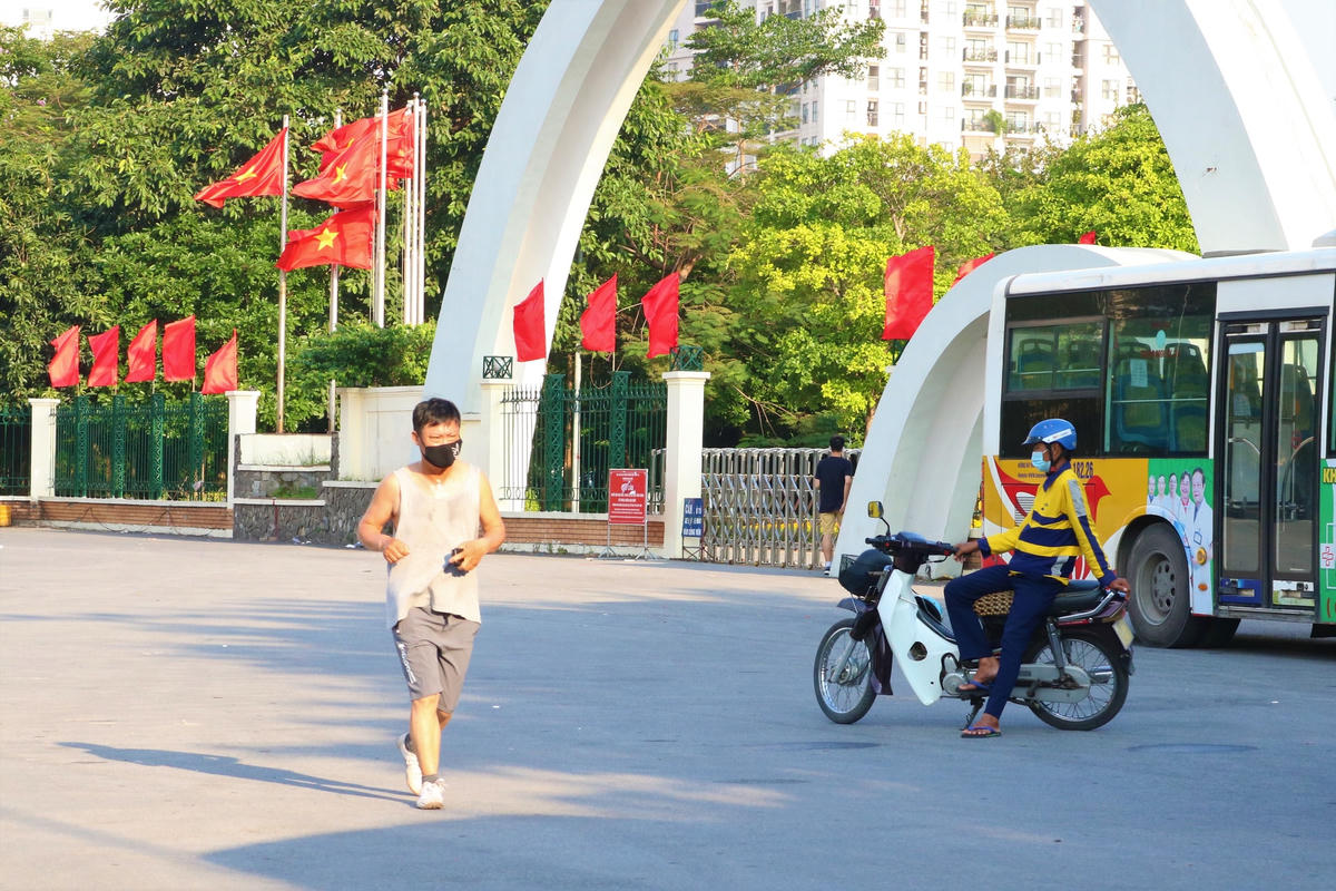 Người dân mang khẩu trang chạy bộ ở khu vực bên ngoài Công viên Cầu Giấy.  