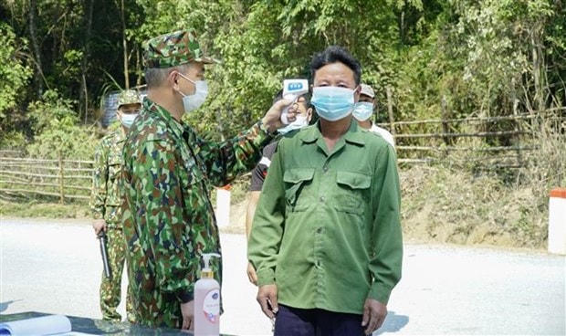 Kiểm tra thân nhiệt đối với người dân qua lại khu vực biên giới. Ảnh: Xuân Tư.  