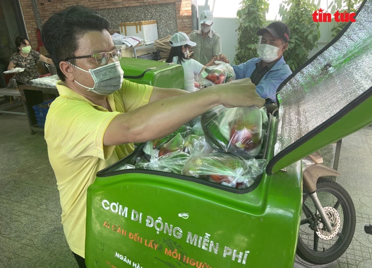 Anh Hải xếp các phần cơm vào trong thùng. Một thùng có thể đựng được 50 phần gồm cơm, thức uống và trái cây kèm theo.