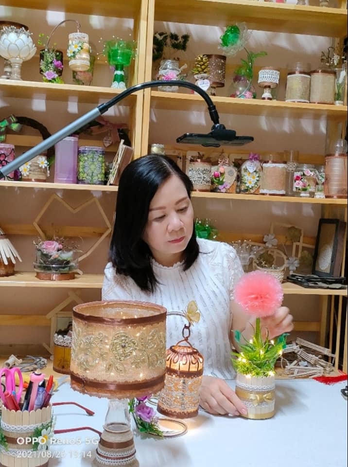 Chị Nguyễn Thị Xuân Hoa bên những sản phẩm tái chế tự mình làm ra. 