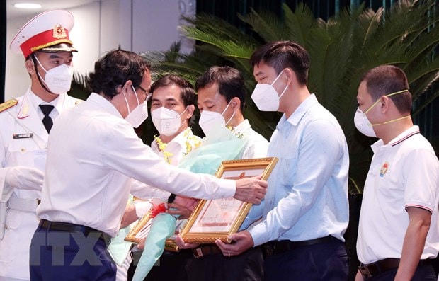 Ông Nguyễn Văn Nên, Ủy viên Bộ Chính trị, Bí thư Thành ủy Thành phố Hồ Chí Minh, trao Bằng khen của UBND thành phố cho đại diện các tập thể có thành tích xuất sắc trong hỗ trợ công tác phòng, chống dịch Covid-19. Ảnh: Xuân Khu/TTXVN.