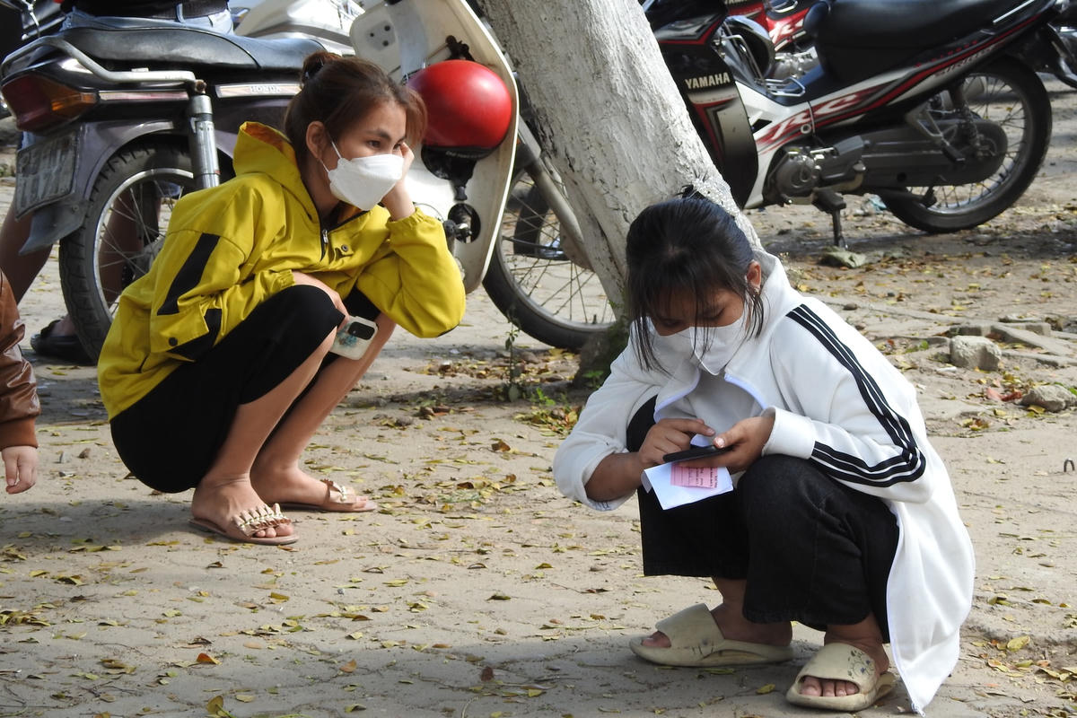 Công nhân mỏi mệt chờ xét nghiệm và chứng nhận hết F0 để đi làm trở lại. Ảnh: Bình Nguyên.