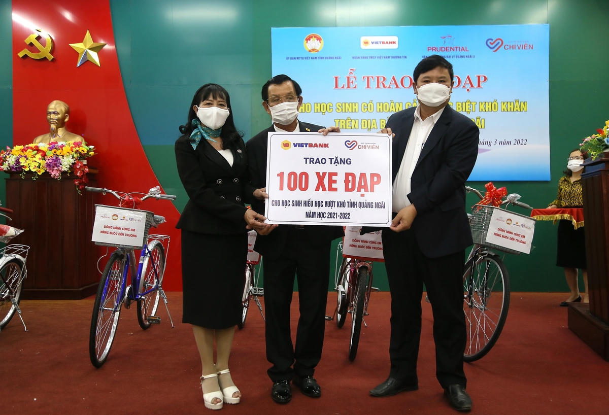 Ông Bùi Đức Thọ (bên phải) tiếp nhận bảng tượng trưng trao tặng 100 chiếc xe đạp cho học sinh khó khăn.