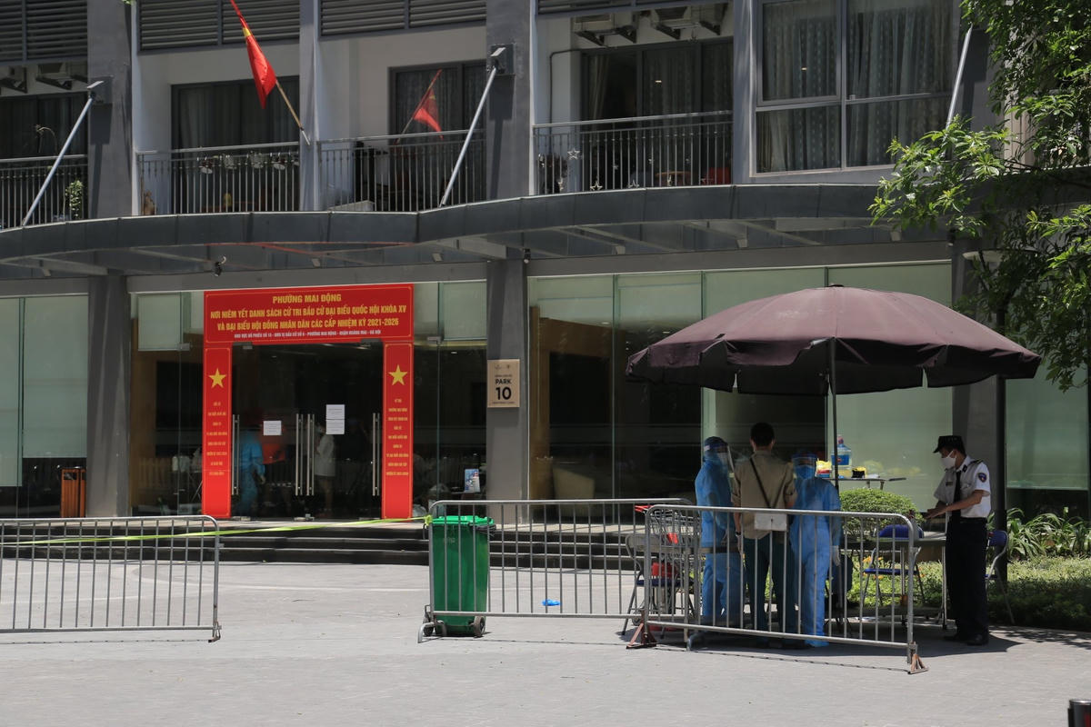 Trước sảnh tòa nhà, nhân viên y tế, bảo vệ đang kiểm soát người ra vào, điều tra dịch tễ.