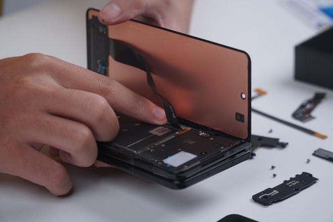 Màn hình phụ phía trước của Galaxy Z Fold3 có thể được mở nhanh chóng bằng phương pháp khò nhiệt. Bên dưới màn hình là hệ thống loa ngoài, loa thoại, camera trước 10 MP và viên pin thứ hai của máy.