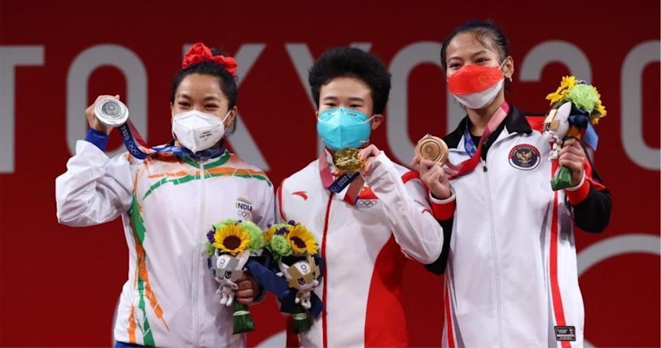 Mirabai Chanu (trái) có thể sẽ được đôn lên nhận huy chương vàng nếu như Zhihui Hou (giữa) bị phát hiện sử dụng chất cấm.