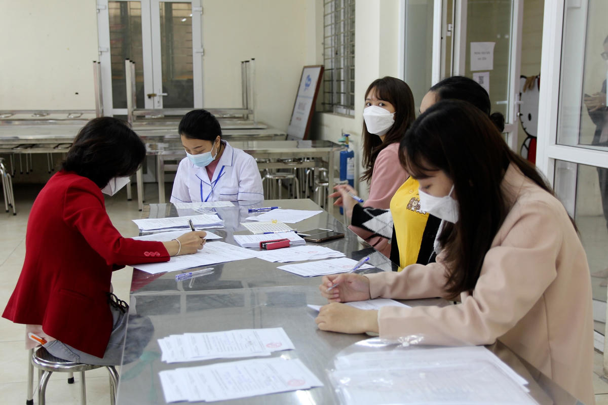 Phụ huynh được hướng dẫn điền thông tin và học sinh được theo dõi sau tiêm.