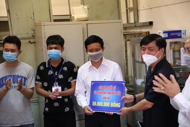Bí thư Tỉnh ủy Đắk Lắk Bùi Văn Cường (ngoài cùng bên phải) trao tặng tiền cho cán bộ y tế.