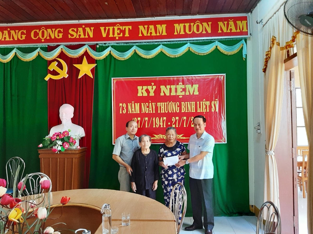Ông Lê Hồng Sơn (bìa phải) thừa ủy quyền của UBTƯ Việt Nam trao quà cho các gia đình thương, bệnh binh.