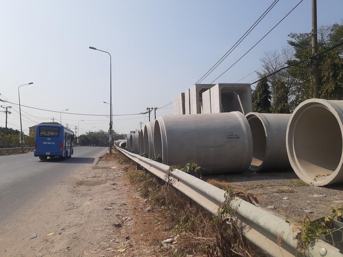 Ống cống tập kết trên hành lang an toàn đường bộ đoạn trước nhà máy bê tông đúc sẵn Hùng Vương, công ty TNHH xây dựng công trình Hùng Vương.