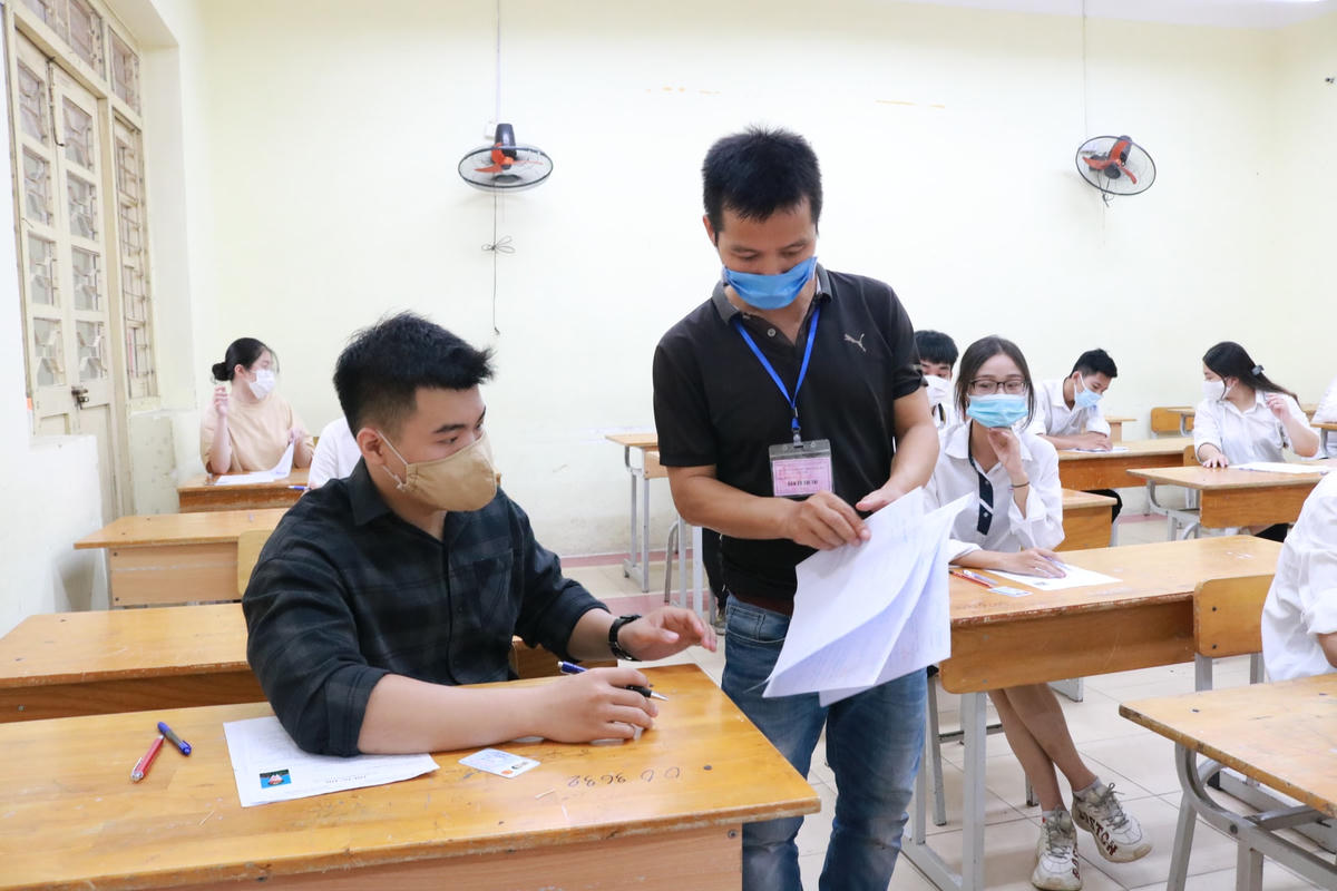 Cán bộ coi thi phát giấy thi cho thí sinh tại Kỳ thi tốt nghiệp THPT 2021.