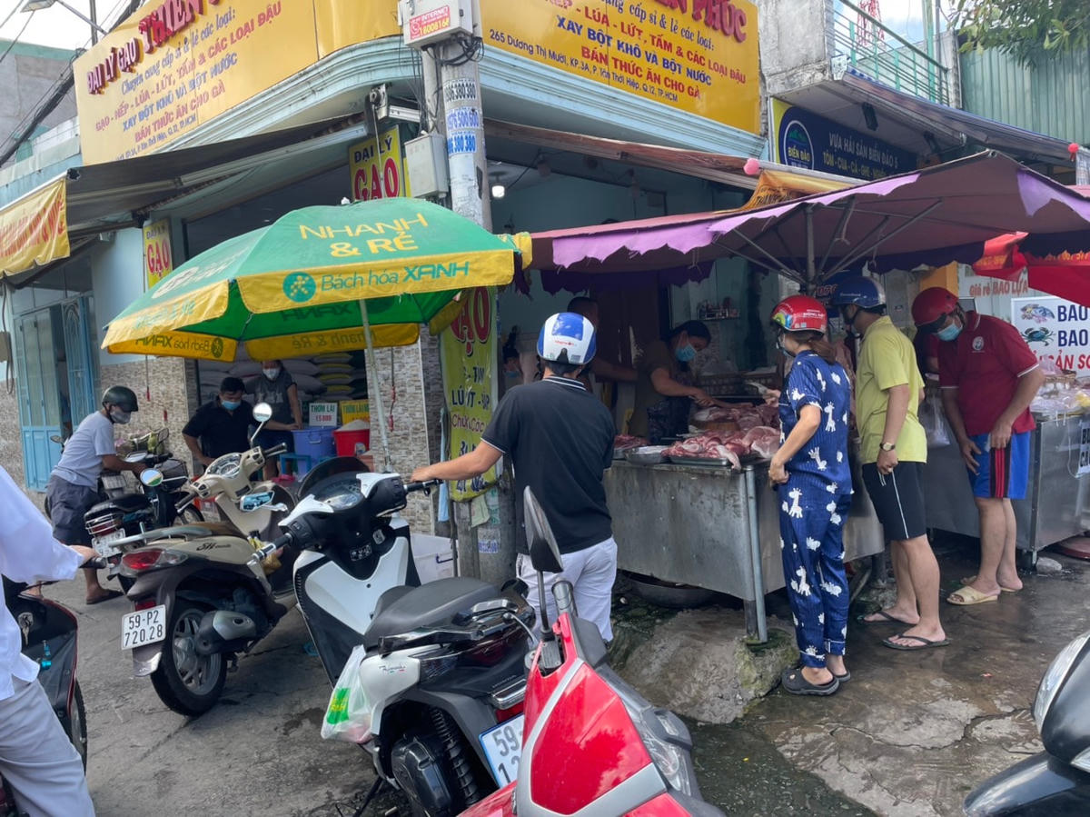 Người dân mua, bán thịt heo tại chợ tự phát đường Dương Thị Mười. Ảnh: Trung Lĩnh.