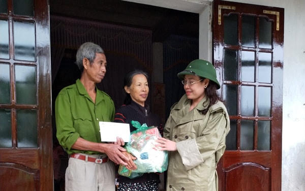 Chủ tịch Ủy ban MTTQ Việt Nam tỉnh Quảng Bình Phạm Thị Hân thăm hỏi một hộ gia đình vừa thoát nạn trong lũ.