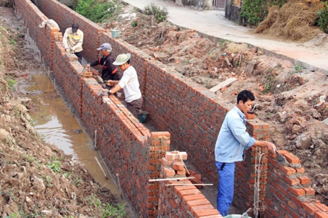 Người dân tham gia xây dựng hệ thống tưới tiêu tại xóm 1, xã Đồn Xá, huyện Bình Lục. Ảnh: Nguyễn Yến.