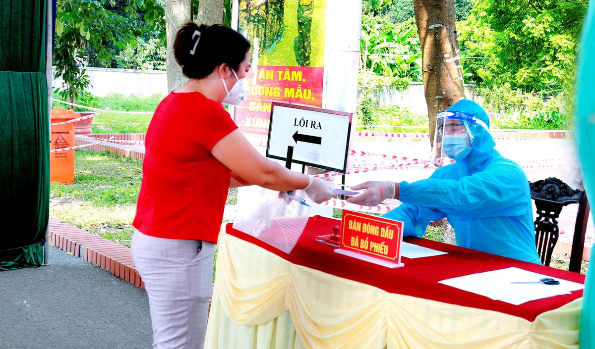 Thành viên tổ bầu cử đóng dấu "đã bỏ phiếu" và đưa lại thẻ cho cử tri.