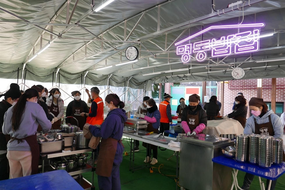 Các tình nguyện viên chuẩn bị phục vụ bữa ăn miễn phí tại “Myeongdong Bab-jib”. Ảnh: Korea Times.