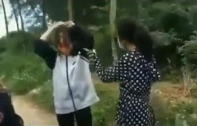 Hình ảnh nữ sinh dùng mũ bảo hiểm đánh bạn (Ảnh cắt từ clip).  