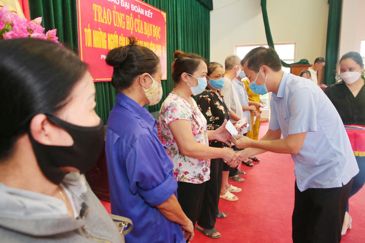 Ông Trần Đăng An, Phó Chủ tịch Ủy ban MTTQ Việt Nam tỉnh Nam Định trao tiền ủng hộ của bạn đọc Báo Đại Đoàn Kết tới người dân phường Lộc Hạ. Ảnh: Viết Dư