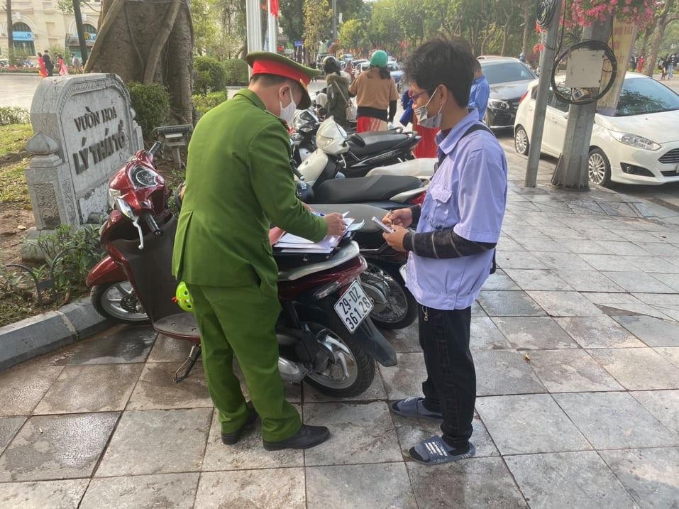 Công an quận Hoàn Kiếm xử phạt đối tượng trông giữ xe. Ảnh: Nam Anh.
