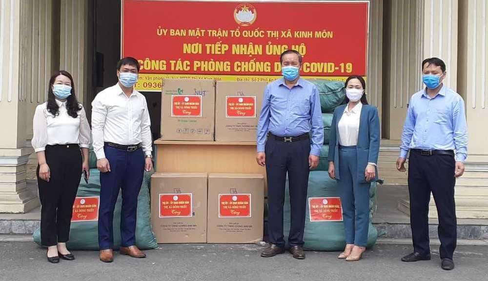 Ông Lại Văn Lương (thứ 2, trái sang), Ủy viên BTV Thị ủy, Trưởng Ban Dân vận Thị ủy, Chủ tịch Ủy ban MTTQ TX Kinh Môn tiếp nhận hỗ trợ của thị xã Đông Triều