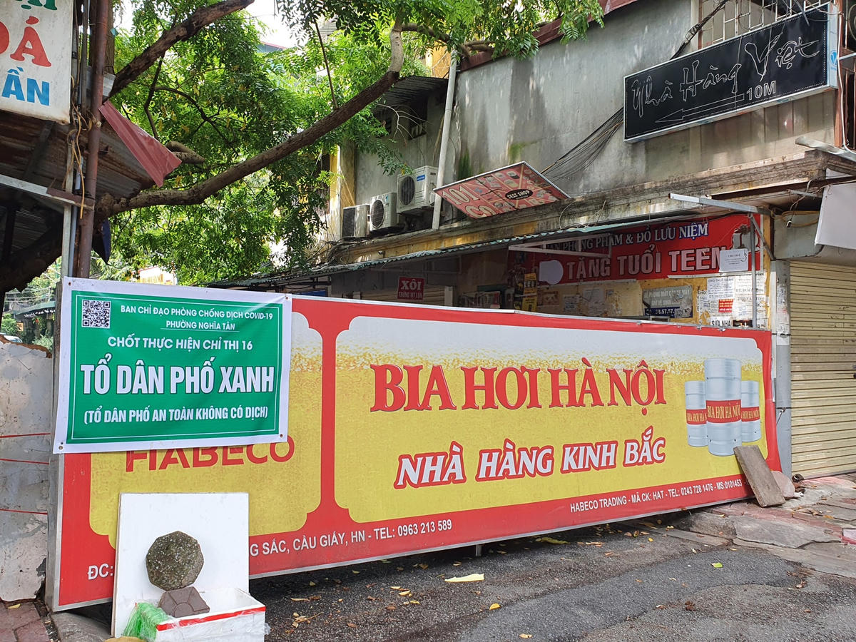 Tấm biển quảng cáo tại một quán bia hơi chặn cứng lối đi tại một con ngõ thuộc phường Nghĩa Tân. 