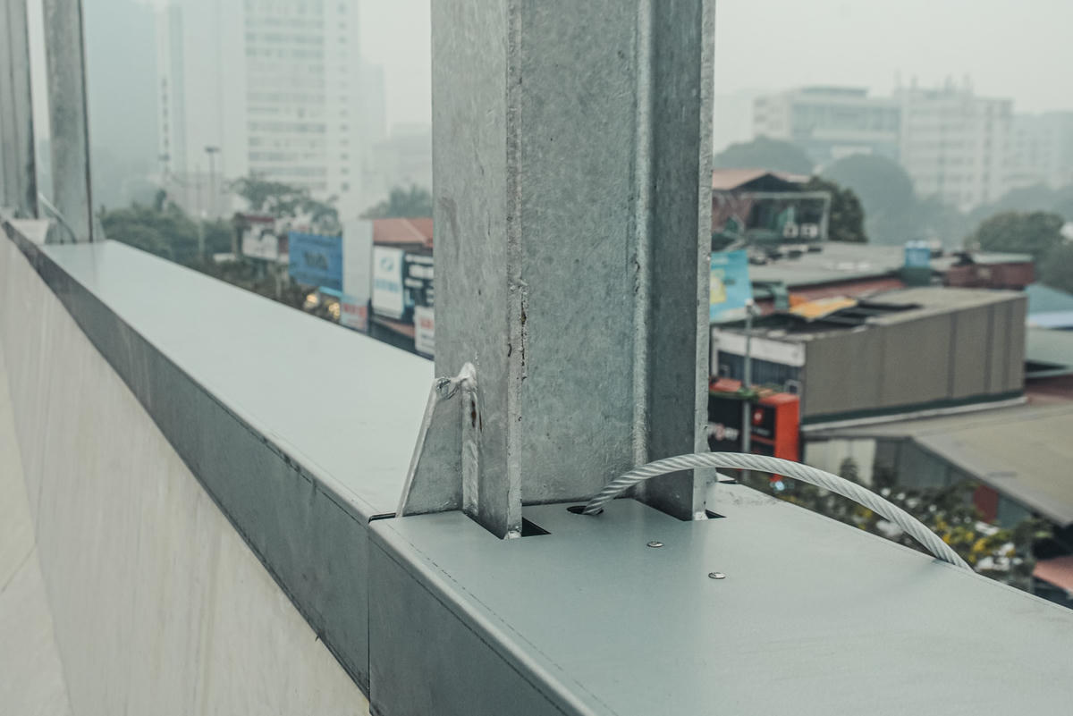 Các cột trụ thép chịu lực được cố định bằng ốc vít khoan trực tiếp vào lan can cầu.
