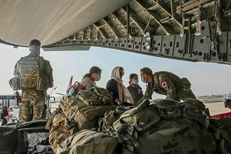 Công dân Anh và người Afghanistan lên máy bay quân sự để sơ tán khỏi sân bay Kabul, Afghanistan, ngày 16/8. Ảnh: Reuters.