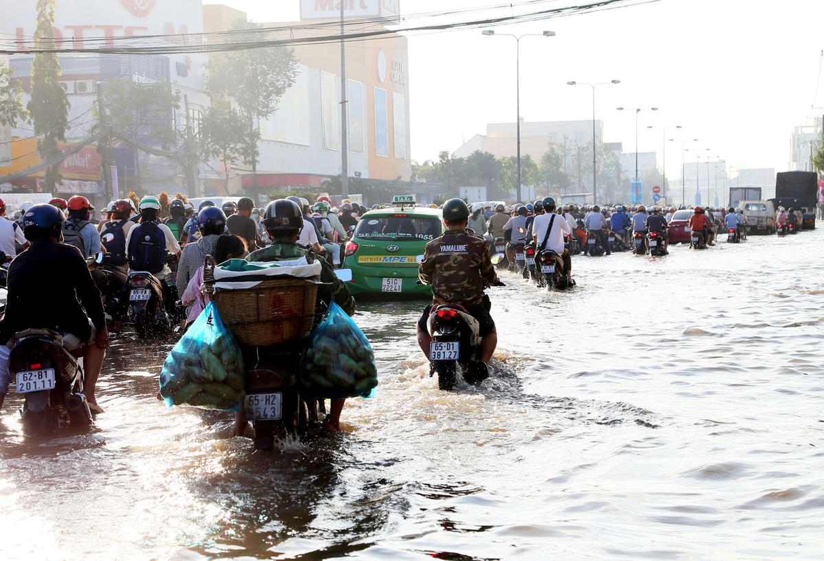 Người dân đi lại khó khăn, mong triều cường nhanh qua giảnt thiệt hại.