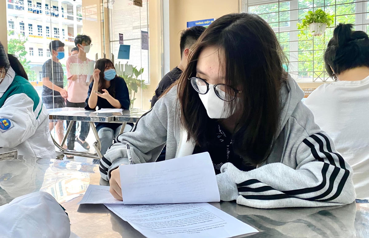Các em học sinh viết phiếu thông tin tiêm vaccine phòng Covid-19.