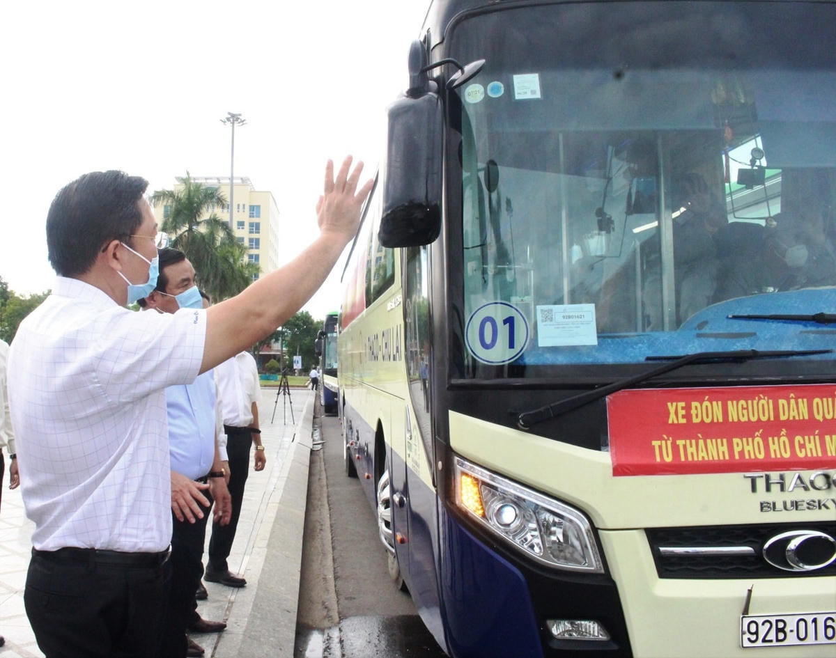 Ông Lê Trí Thanh, Chủ tịch UBND tỉnh vẫy tay chào đoàn xe đưa đón đồng bào về quê.