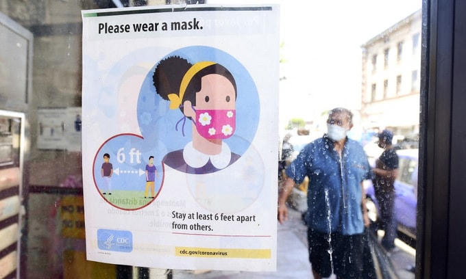 Bảng nhắc nhở người dân đeo khẩu trang, giữ khoảng cách tại bang California, Mỹ, hôm 19/7. Ảnh: AFP.