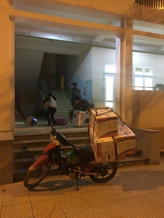 Học sinh lớp 3E và phụ huynh chuẩn bị tư trang, đồ dùng cách ly tập trung. (Nguồn: Ngọc Hà) 