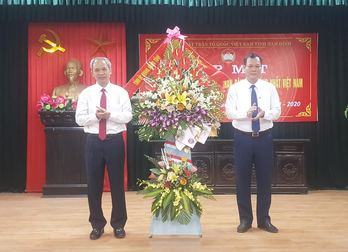 Phó Bí thư Thường trực Tỉnh ủy Nam Định Lê Quốc Chỉnh (bên phải) tặng hoa, chúc mừng MTTQ Việt Nam tỉnh nhân ngày truyền thống.