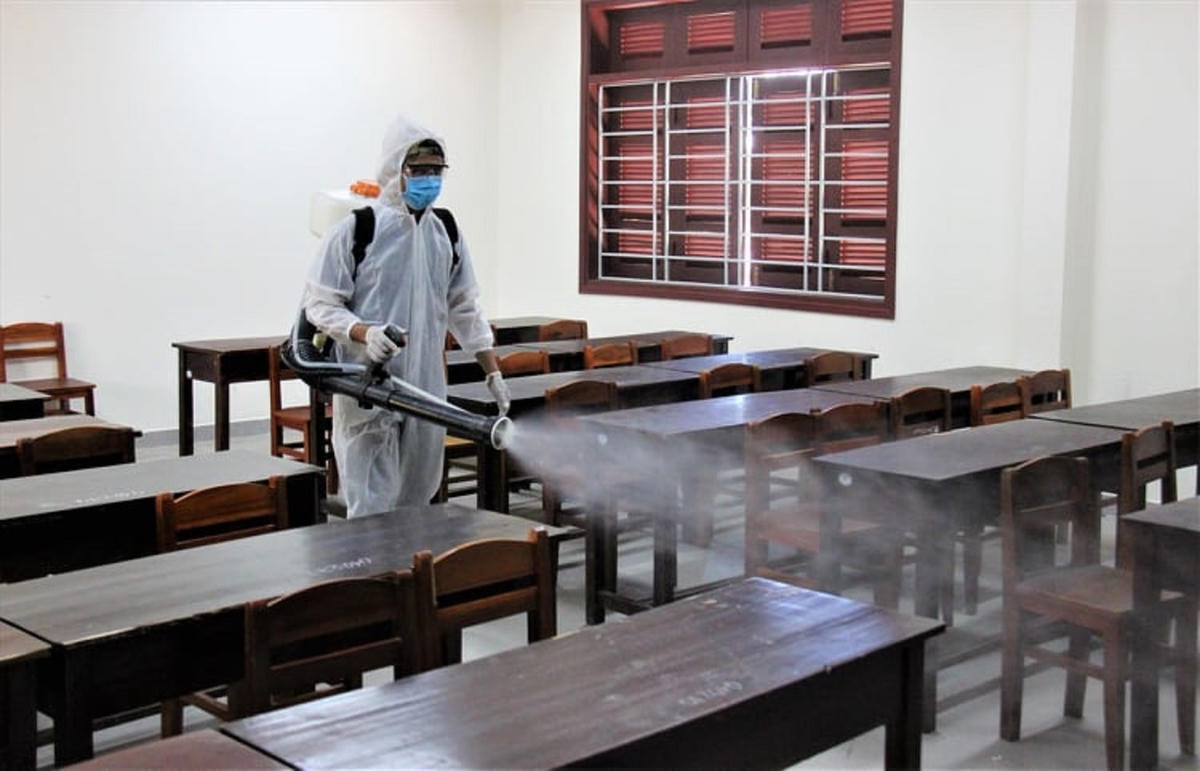 Nhân viên phun thuốc khử trùng ở điểm thi Trường THPT Nguyễn Dục.