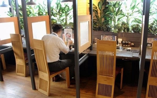 Chỗ ngồi nhà hàng phục vụ Ohitorisama thường hướng vào đường băng chuyền và đều có riêng một khay đựng gia vị cùng một thiết bị chọn món. Ảnh: Japan Times.