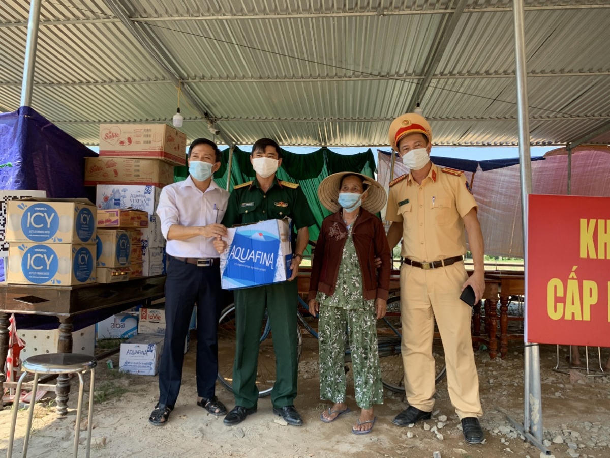 Cụ Sừng trao tặng thùng nước suối cho lực lượng đang làm nhiệm vụ tại chốt giám sát dịch tễ số 3.