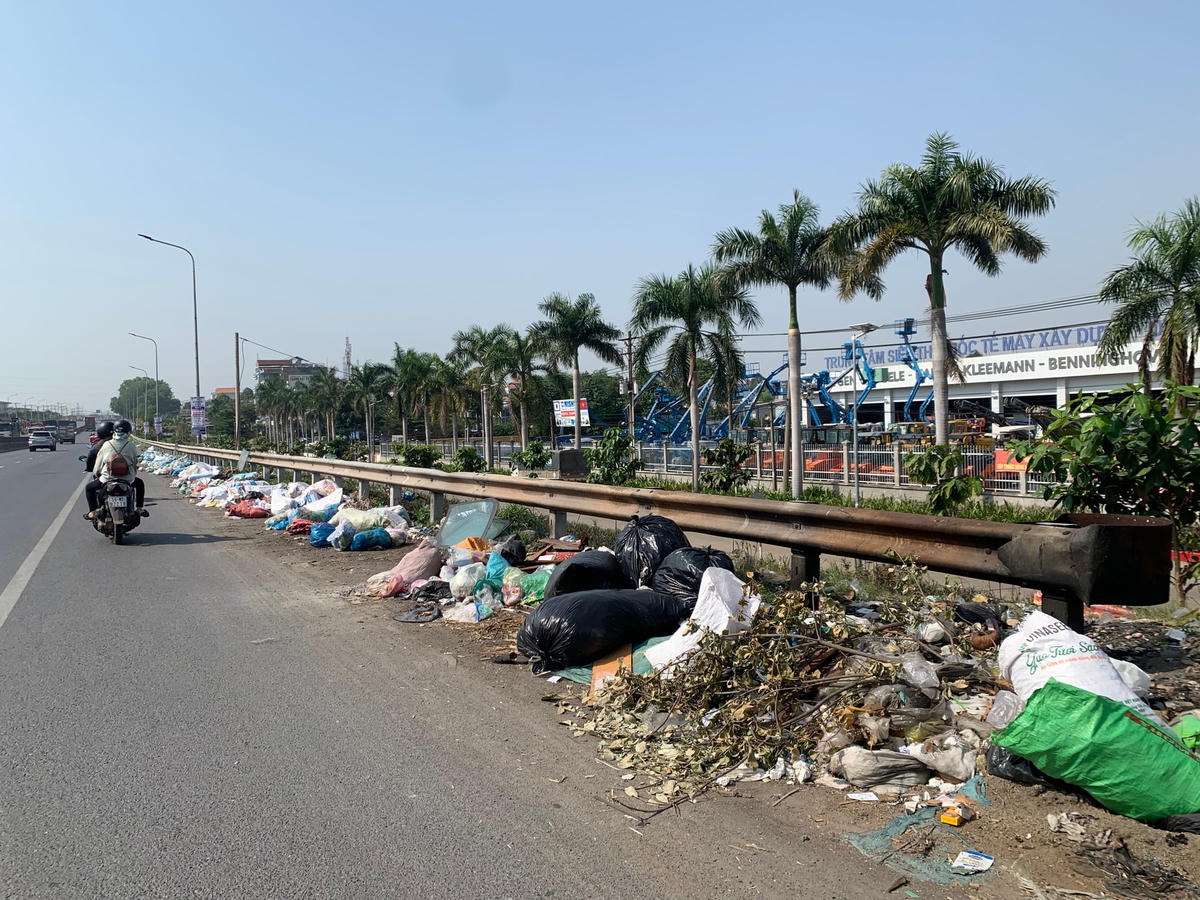 Rác ngập đường kéo dài khoảng 100m trên Quốc lộ 1A (đoạn trước trung tâm siêu thị quốc tế máy xây dựng - ô tô chuyên dùng phụ tùng và dịch vụ bảo hành, phường Bình Đa).