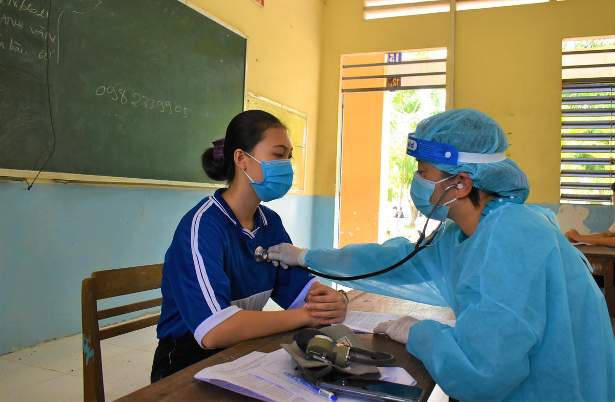 Lực lượng y tế xã Quốc Thái khám sàng lọc học sinh Trường THPT Quốc Thái trước khi tiêm vaccine phòng Covid-19. Ảnh: Thành Nhân