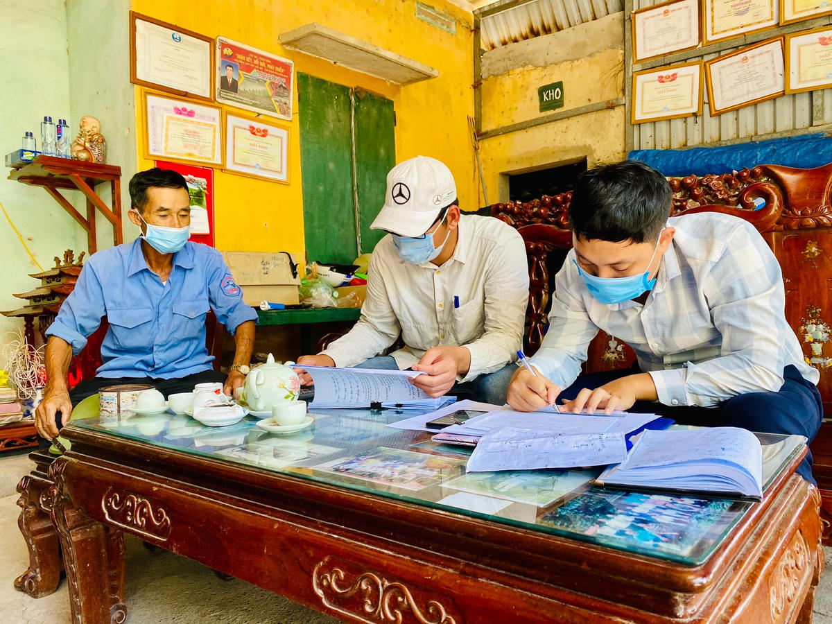 Ông Nguyễn Văn Khang (ngồi bên trái) cung cấp thông tin, hỗ trợ các cán bộ, nhân viên Trung tâm Phát triển Quỹ đất TX Quảng Yên trong việc đo đạc, kiểm đếm tài sản.