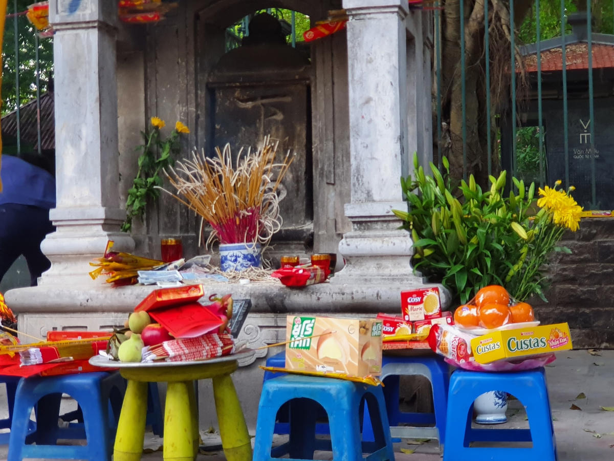 Lễ vật được đặt trên những chiếc ghế nhựa bao gồm hoa quả, kẹo bánh, nến, hương...