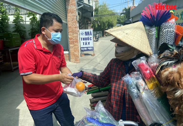 Anh Khởi gửi phần cơm cho một người đi ngang qua bếp ăn.