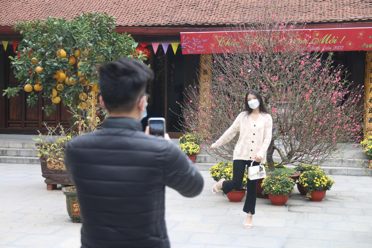 Đôi bạn trẻ chụp ảnh đang du Xuân tại chùa Hà.