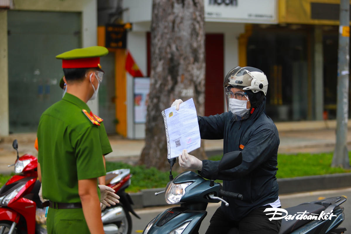 Lực lượn chức năng kiểm tra giấy đi đường của người dân.