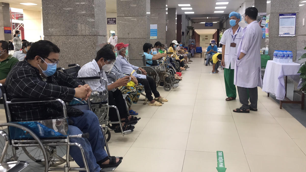Người khuyết tật chờ xét nghiệm trước khi tiêm.